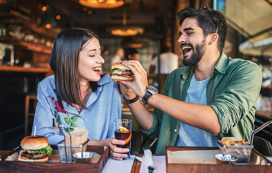 Man and woman eating burgers