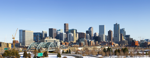 Wide view of Denverâ€™s city skyline from the west side of town, with snow on the ground.