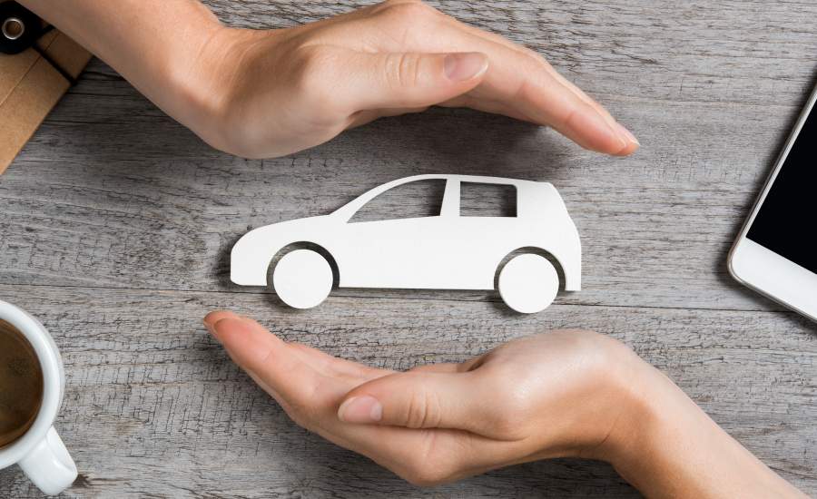 paper cut out of car framed by hands