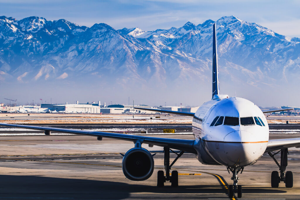 Beautiful view of snow covered mountains with an airplane in the foreground.