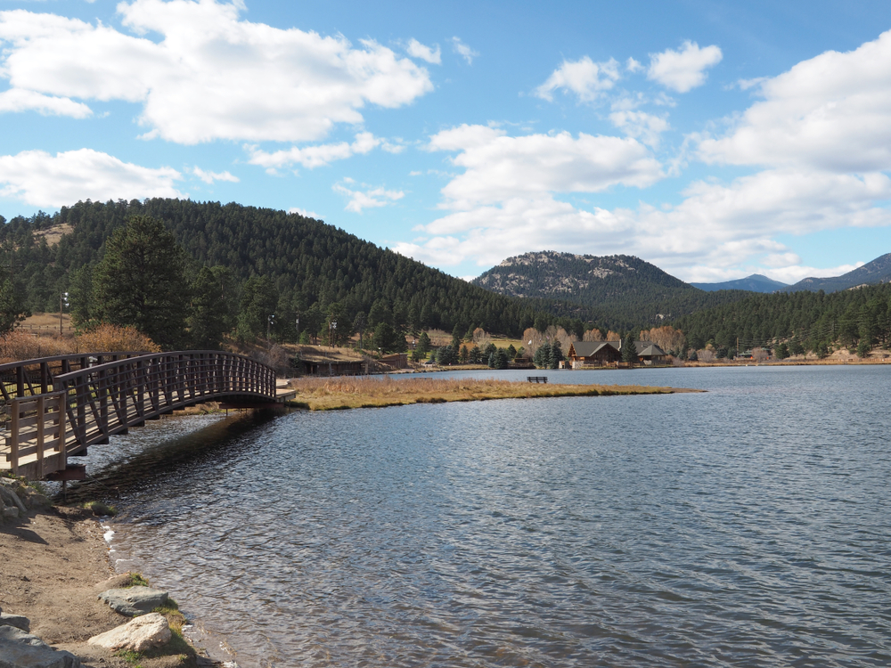 A wooden bridge spans the Evergreen Lake in Evergreen, Colorado.