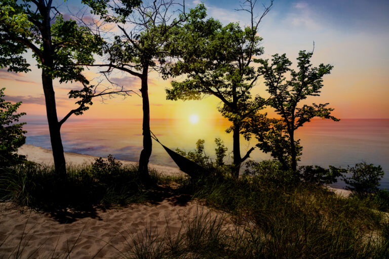 The silhouette of Indiana Dunes State Park landscape overlooking Lake Michigan at sunset near Porter, Indiana, USA.