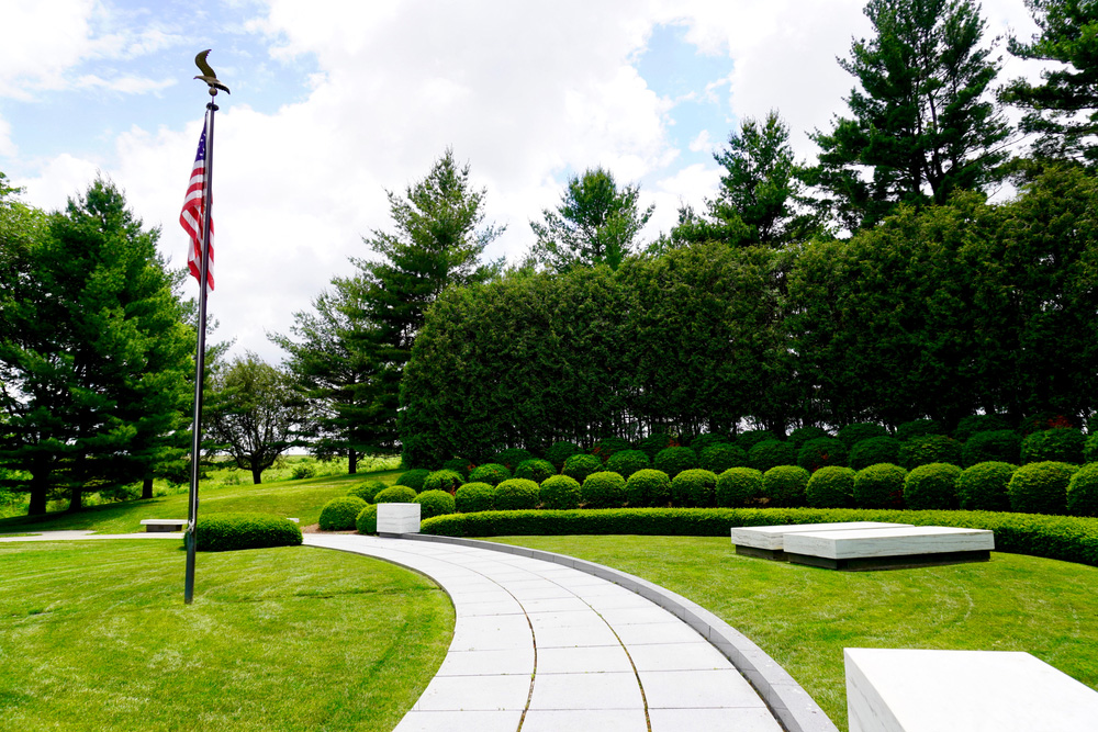 Herbert Hoover National Historic Site in West Branch, Iowa. The gravesite of President Hoover and Lou Henry Hoover. Two marble ledger stones mark graves in a semicircular landscaped plot with a flag.