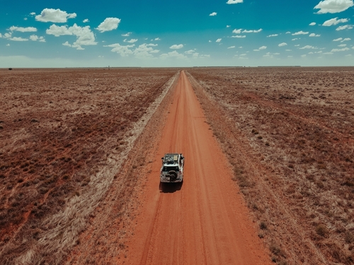 car headed down a desert road 