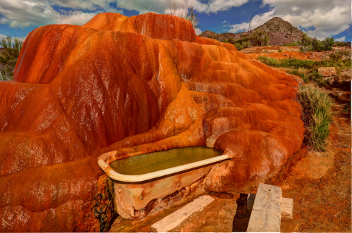 A vintage bathtub partly covered in mineral deposits at Mystic Hot Springs..
