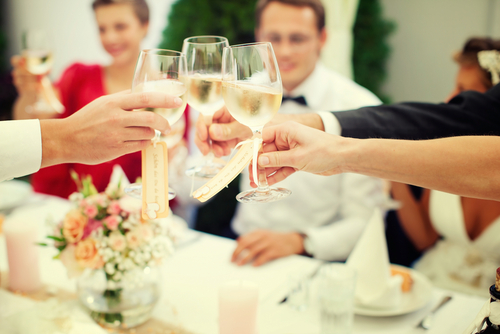 Wedding party clinking wine glasses together