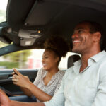 Close up portrait of man and woman in car smiling