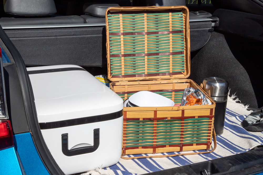 Picnic Basket with Snacks and a Cooler in the Trunk of a Car