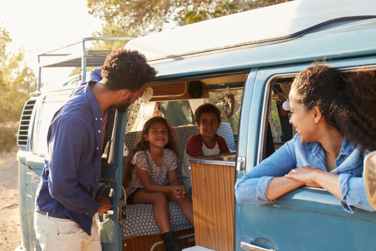 Family on a road trip making a stop in their camper van.